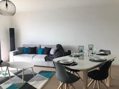 a living room with a table and chairs and a couch at Bel appartement f3 vue sur le golfe d’ajaccio in Ajaccio