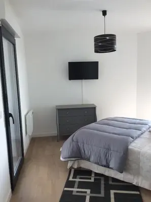 a bedroom with a bed and a television on a wall at Bel appartement f3 vue sur le golfe d’ajaccio in Ajaccio