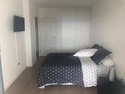 a bedroom with a bed with a black and white comforter at Bel appartement f3 vue sur le golfe d’ajaccio in Ajaccio