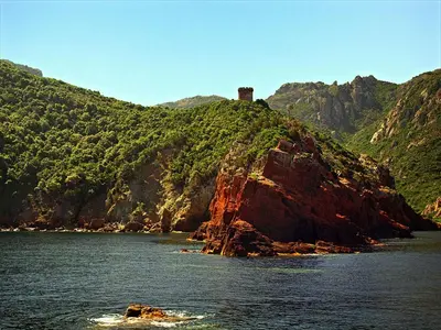 a castle on top of a mountain in the water at Maison de caractère, pierre sèche, Galéria, pour 2 in Galeria