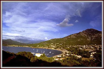 a view of a beach with boats in the water at Maison de caractère, pierre sèche, Galéria, pour 2 in Galeria
