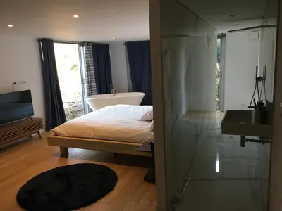 a bedroom with a bed and a tub and a sink at Villa Leccia di Lorello in Grosseto-Prugna
