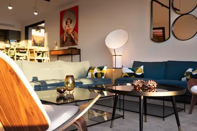 a living room with a blue couch and tables at Villa EVA, vue mer et montagne, plage à pieds in Sainte-Lucie de Porto-Vecchio