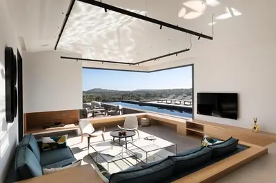 a living room with a couch and a tv at Villa EVA, vue mer et montagne, plage à pieds in Sainte-Lucie de Porto-Vecchio