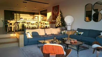 a living room with blue couches and a christmas tree at Villa EVA, vue mer et montagne, plage à pieds in Sainte-Lucie de Porto-Vecchio