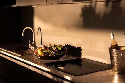 a bowl of vegetables on a kitchen counter with a bottle of wine at Villa EVA, vue mer et montagne, plage à pieds in Sainte-Lucie de Porto-Vecchio