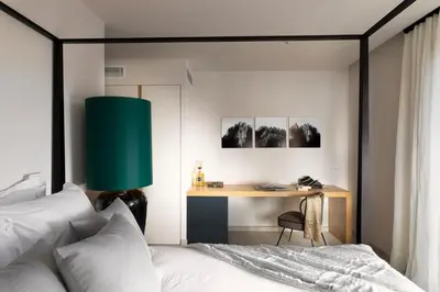 a bedroom with a bed and a desk with a green lamp at Villa EVA, vue mer et montagne, plage à pieds in Sainte-Lucie de Porto-Vecchio