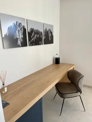 a desk in a room with a chair and pictures on the wall at Villa EVA, vue mer et montagne, plage à pieds in Sainte-Lucie de Porto-Vecchio