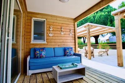a blue couch on a porch with a table at Campo Vecchio Mare et Piscine in Ghisonaccia