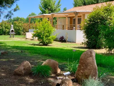 a house with rocks in front of a yard at Campo Vecchio Mare et Piscine in Ghisonaccia