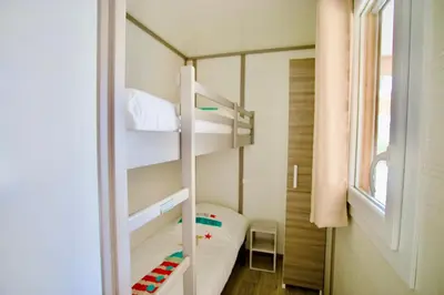 a small bedroom with a bunk bed and a window at Campo Vecchio Mare et Piscine in Ghisonaccia