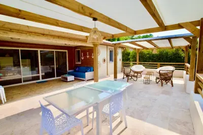 a patio with a glass table and chairs on it at Campo Vecchio Mare et Piscine in Ghisonaccia