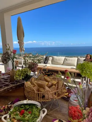 a table with food and a view of the ocean at Villa Mare d'argentu La solenzara in Sari Solenzara