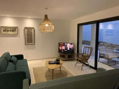 a living room with a couch and a tv at Villa Mare d'argentu La solenzara in Sari Solenzara