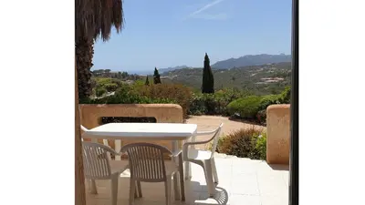 a table and chairs on a patio with a view at Résidence Liccia di Furu in Porto-Vecchio