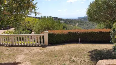 a white bench sitting in front of a hedge at Résidence Liccia di Furu in Porto-Vecchio