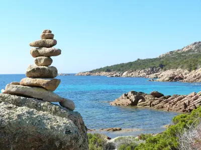 a stack of rocks sitting on top of a rock tower at Résidence Liccia di Furu in Porto-Vecchio