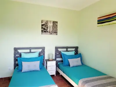two beds in a room with blue pillows at U mè sognu in Arbellara