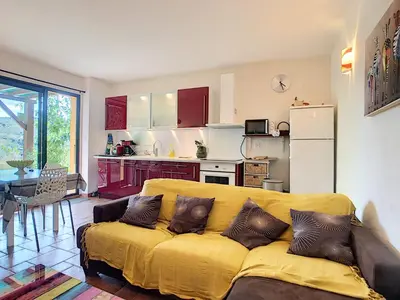 a living room with a yellow couch and a kitchen at U mè sognu in Arbellara
