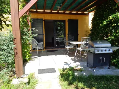 an outdoor patio with a grill and a table at U mè sognu in Arbellara