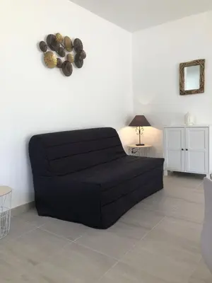 a black couch sitting in a living room at U SOLE in Ajaccio