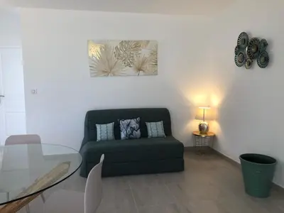 a living room with a green couch and a glass table at U SOLE in Ajaccio