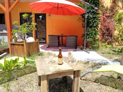 a table with wine glasses and an umbrella at Alegria in Arbellara