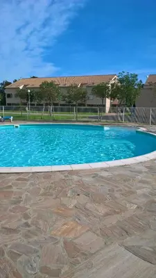a large blue swimming pool in front of a building at Villa Fior 50 in Santa-Maria-Poggio