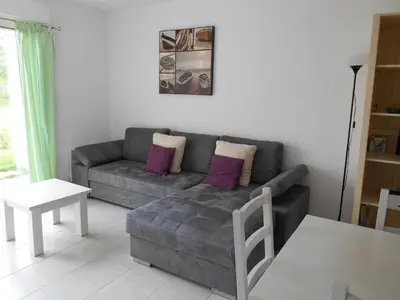 a living room with a gray couch with purple pillows at Villa Fior 50 in Santa-Maria-Poggio