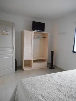 a bedroom with a bed and a tv on top of a cabinet at Villa Fior 50 in Santa-Maria-Poggio