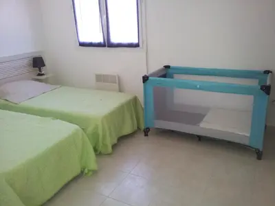 a room with two beds and a blue dresser in it at Villa Fior 50 in Santa-Maria-Poggio
