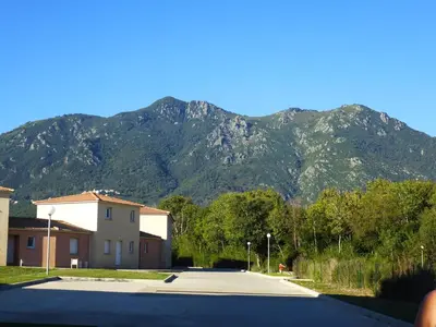 a mountain in the distance with a building and a road at Villa Fior 50 in Santa-Maria-Poggio