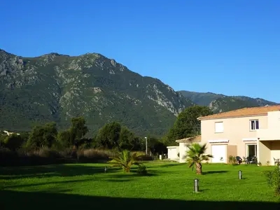 a house with a mountain in the background at Villa Fior 50 in Santa-Maria-Poggio