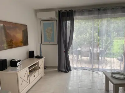 a living room with a large window and a table at Villa Fior 50 in Santa-Maria-Poggio