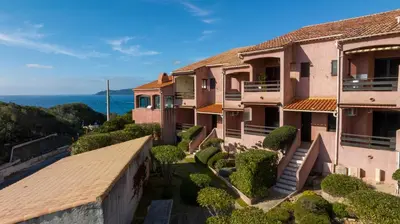 an aerial view of a resort next to a body of water at La Punta Geronimi in Porto Pollo