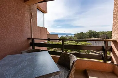 a table and chairs on a balcony with a view at La Punta Geronimi in Porto Pollo