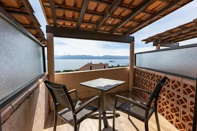 a table and two chairs on a balcony with a view at La Punta Geronimi in Porto Pollo