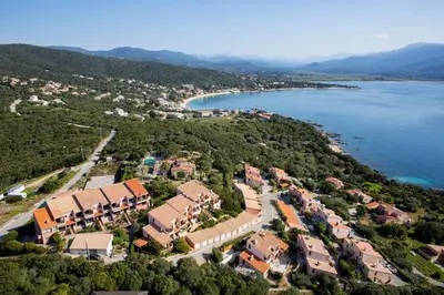 an aerial view of a building with the ocean in the background at La Punta Geronimi in Porto Pollo