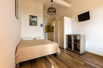 a small bedroom with a bed and a television at La Punta Geronimi in Porto Pollo