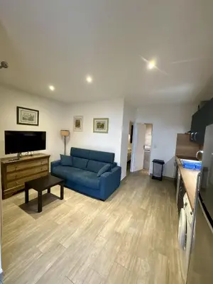 a living room with a blue couch and a tv at La Punta Geronimi in Porto Pollo