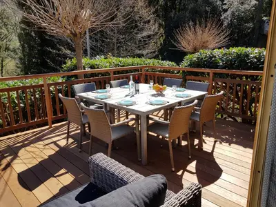 a wooden deck with a table and chairs on it at Casa Del Torrente in Porto Ota