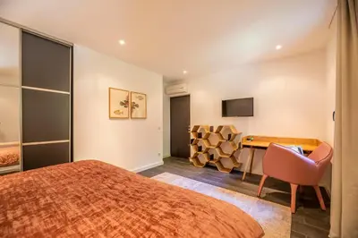 a bedroom with a bed and a desk and a chair at Domaine & Villas Version Maquis in Bonifacio