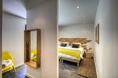 a bedroom with a bed and a mirror at Domaine & Villas Version Maquis in Bonifacio
