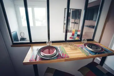 a table with plates and glasses on top of a window at Studio cosy les pieds dans l'eau, climatisé, Parking privé, Vue montagne in San-Nicolao