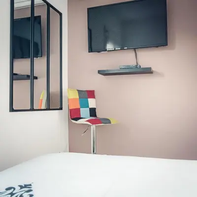 a chair in a room with a tv on the wall at Studio cosy les pieds dans l'eau, climatisé, Parking privé, Vue montagne in San-Nicolao