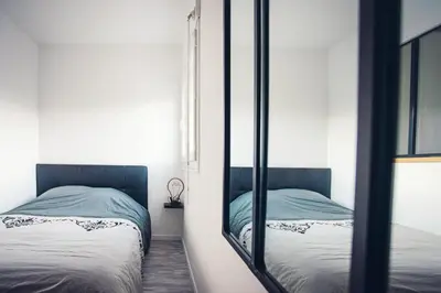 a bedroom with two beds and a mirror at Studio cosy les pieds dans l'eau, climatisé, Parking privé, Vue montagne in San-Nicolao