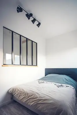 a bedroom with a bed with a light on the wall at Studio cosy les pieds dans l'eau, climatisé, Parking privé, Vue montagne in San-Nicolao