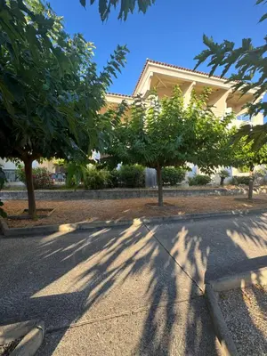 a building with trees in front of a street at Appartements PORTICCIO CENTRE in Porticcio