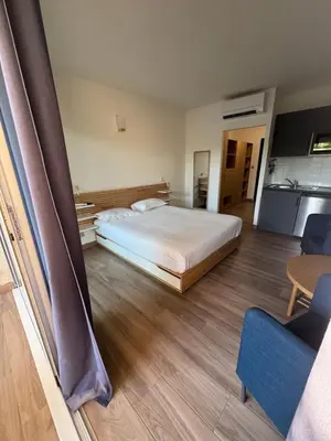 a large bedroom with a bed and a kitchen at Appartements PORTICCIO CENTRE in Porticcio