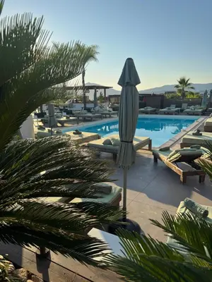 a swimming pool with a umbrella and lounge chairs at Appartements PORTICCIO CENTRE in Porticcio